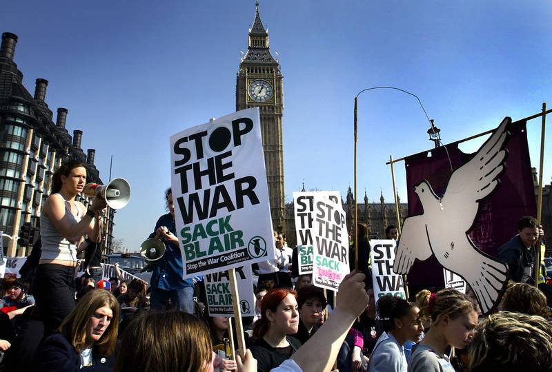 Anti-war demonstrators stage a sit-down protest outside the Houses of Parliament