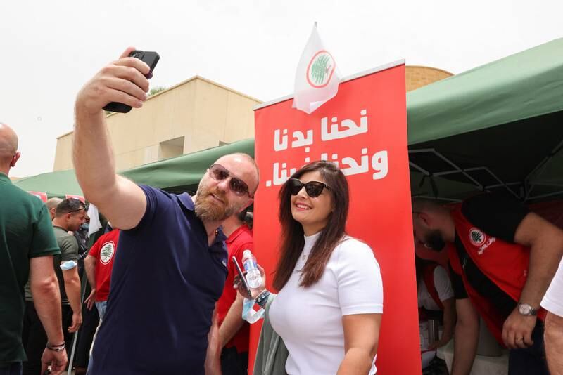 Lebanese expats take selfie in front of an election banner as they arrive to cast their vote in Lebanon's parliamentary election at the Lebanese Embassy in Riyadh, Saudi Arabia. Reuters