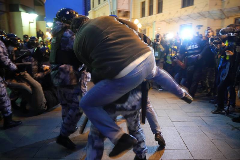 A demonstrator struggles with police in an attempt to prevent a fellow protester from being arrested. AP