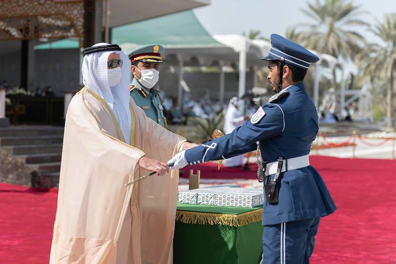 Sheikh Saif hands the sword of honour to cadet Mohamed Al Qorsi Al Ali, who graduated first in his class for total marks, academic sciences and special training. Wam