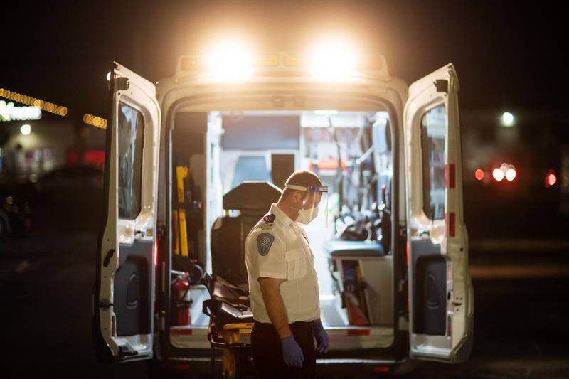 An EMT pauses for a moment while loading a stretcher back into an ambulance after dropping off a patient at a newly opened field hospital operated by Care New England for Covid-19 patients in Cranston, Rhode Island. AP Photo