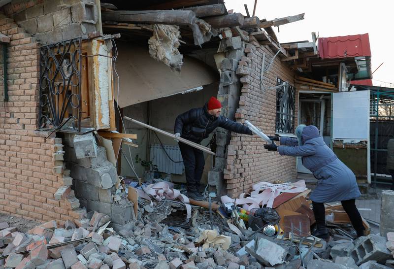 Residents remove debris and carry their belongings out of a building destroyed by recent shelling in Donetsk, Russian-controlled Ukraine. Reuters