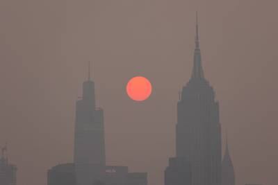 Buildings in the Manhattan skyine shrouded in smoke from Canadian wildfires at sunrise in Jersey City, New Jersey. Bloomberg