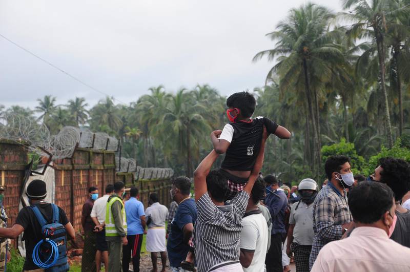 People gather to look at the Air India Express flight that skidded off a runway while landing at the airport in Kozhikode, Kerala state. AP Photo