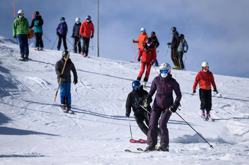 Skiers, some wearing protective face masks, take to the slopes. AFP