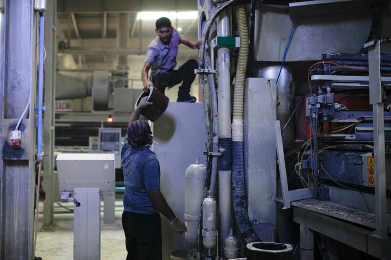 Ras Al Khaimah, June 19, 2013 - Workers change the filters the machines that press tiles at the RAK Ceramics factory in Ras Al Khaimah, June 19, 2013. (Photo by: Sarah Dea/The National)


     This set of photos is for a photo page in Business to run over Ramadan 2013. DO NOT USE BEFORE THEN. *** Local Caption ***  SDEA190613-rakceramics10.JPG