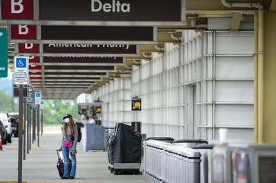ARLINGTON, VA - MAY 05: A traveler wears a face covering as she arrives at the terminal at Ronald Reagan Washington National Airport, May 5, 2020 in Arlington, Virginia. Most major airlines are now requiring passengers to wear face coverings to help prevent the spread of the coronavirus.   Drew Angerer/Getty Images/AFP
== FOR NEWSPAPERS, INTERNET, TELCOS & TELEVISION USE ONLY ==

