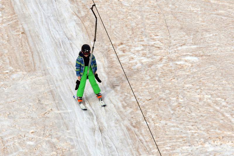 A child takes a ski lift as sand from Sahara fell overnight covering the snow in Piau-Engaly ski resort, southwestern France.  AFP
