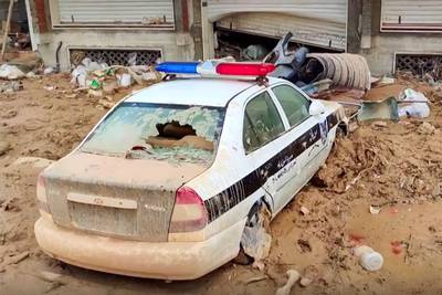 A police vehicle washed away by floods lies on a street in Derna. AFP