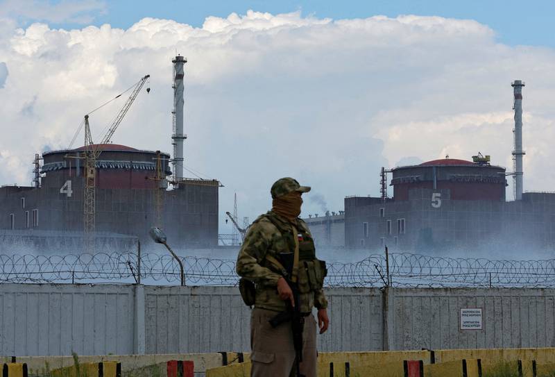 A serviceman with a Russian flag on his uniform stands guard near Ukraine's Zaporizhzhia nuclear power plant outside the Russian-controlled city of Enerhodar.  Reuters