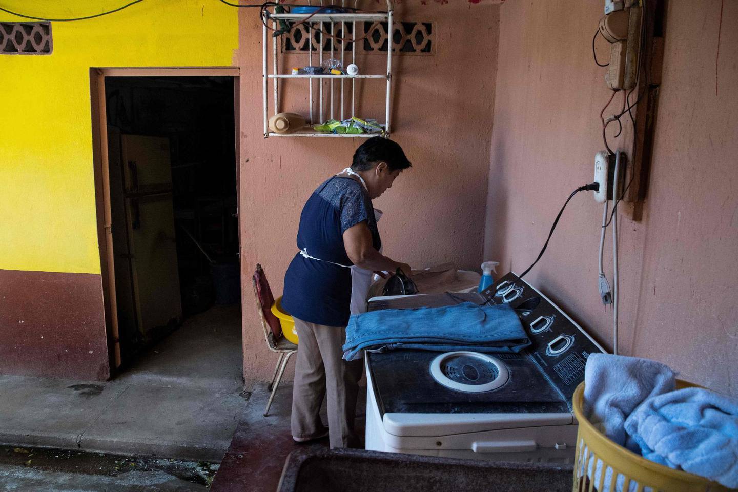 Costa Rican domestic worker Aracelly Calvo irons clothes at the house where she works in Guanacaste, Canas, Costa Rica on January 04, 2019.  The working conditions of domestics in Latin America, to whom director Alfonso Cuaron pays homage in his recent movie 'Roma', is slowly reaching a legal framework. Whilst several countries in the region have established laws for the sector in the last decade, other simultaneous realities such as economic crises and migration, are hampering those conquests and ambitions of formality. / AFP / Ezequiel BECERRA
