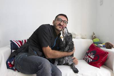 Samer Alogidi, the owner Pooch Parlour in Abu Dhabi, with one of his regulars, Hunter, a 14-year-old American Cocker Spaniel. Mona Al Marzooqi / The National