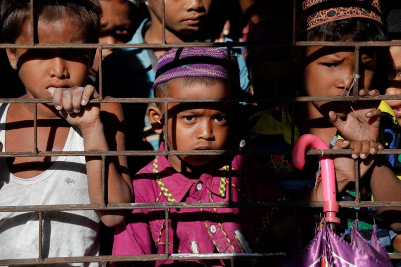 Students of a local madrasa watch from inside their classroom as bodies of Rohingya refugees from Myanmar, who were killed when their boat capsized on the way to Bangladesh, are brought to their school in Shah Porir Dwip, in Teknaf, near Cox's Bazar in Bangladesh. Damir Sagolj / Reuters