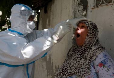 A woman reacts as a swab sample is taken from her nose for a coronavirus test in a suburb of the Jordanian capital Amman. AFP