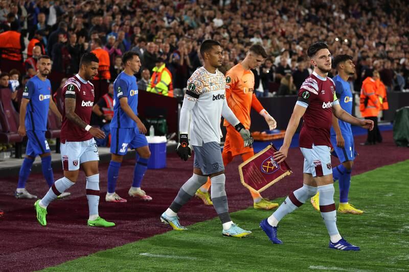 Players walk on to the pitch wearing black armbands at West Ham. Getty