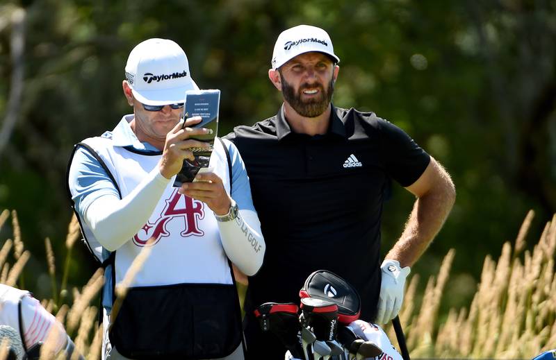 Dustin Johnson and his caddie wait to hit on the seventh hole during round two of the LIV Golf Invitational - Portland. Getty
