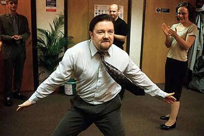David Brent, played by Ricky Gervais, shows off some dance moves to his co-workers in The Office.