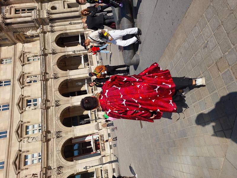 A man in an amazing woven coat,  outside Louis Vuitton.
