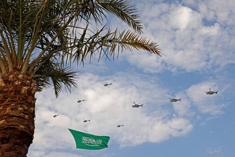 Helicopters carry a giant Saudi flag over Riyadh. 