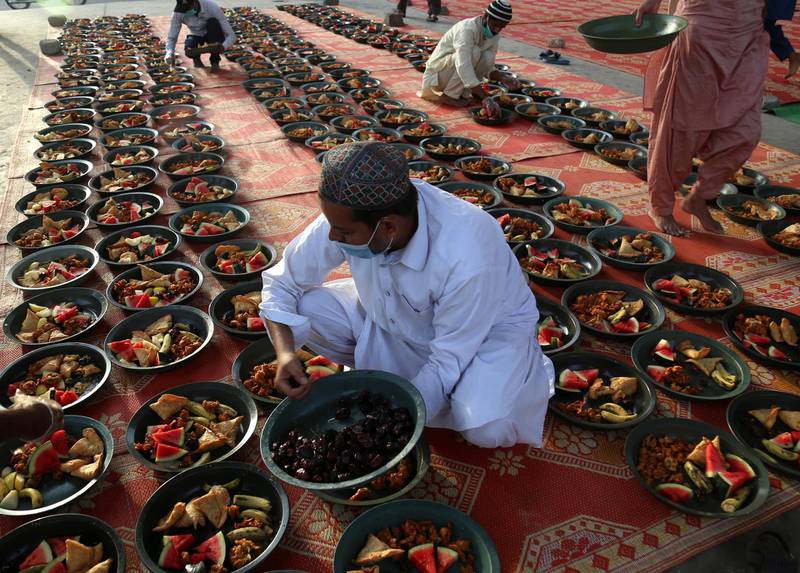 Pakistani men place food for the people to break their fast on a roadside tent during Ramadan in Karachi, Pakistan. EPA