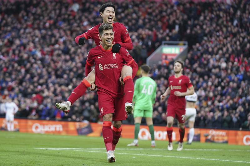 Takumi Minamino celebrates with Roberto Firmino after scoring Liverpool's third goal during the Premier League match against Brentford at Anfield on Sunday, January 16, 2022. AP