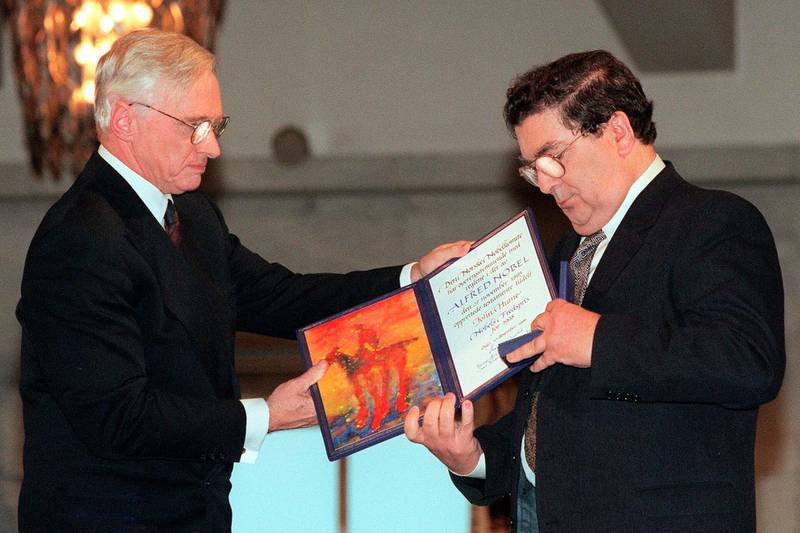 In this December 10, 1998 file photo, John Hume, right, looks at the Nobel Peace Prize diploma that he received from Francis Sejersted, left, chairman of the Norwegian Nobel Peace Prize Committee, during the award ceremony in Oslo Town Hall. AP Photo