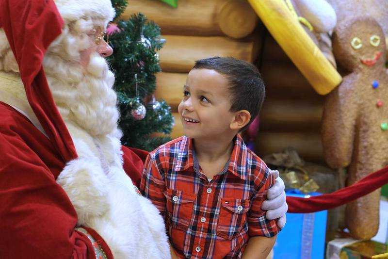 Benjamin Kamber, 4, hands Santa his Christmas wish list. Delores Johnson / The National