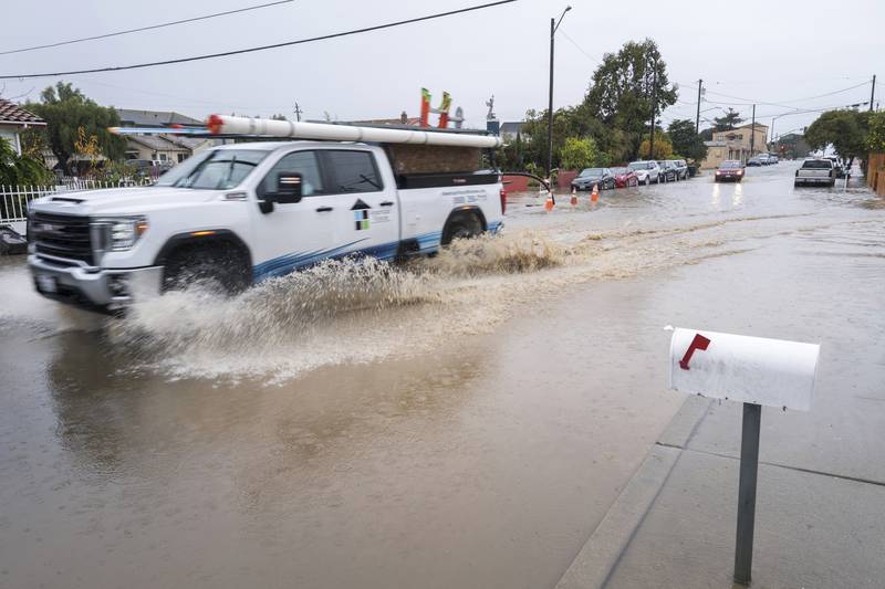 A pick-up truck is driven through a flooded junction in Salinas, California. AP