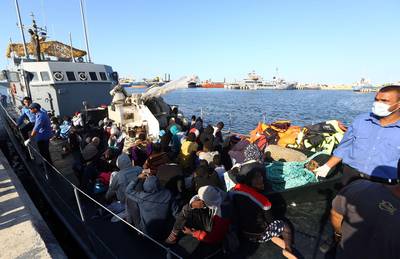 (FILES) In this file photo taken on October 11, 2017, African migrants arrive at a naval base in the Libyan capital Tripoli, after they were rescued from a rubber boat by coastguards off the Libyan coast of Sabratha.  France cancelled a decision to deliver six twelve-meter-long Sillinger rigid inflatable boats to Libyan authorities, initially intended to strengthen coastal patrols, due to the "situation" in the North African country, according to concordant sources. / AFP / MAHMUD TURKIA
