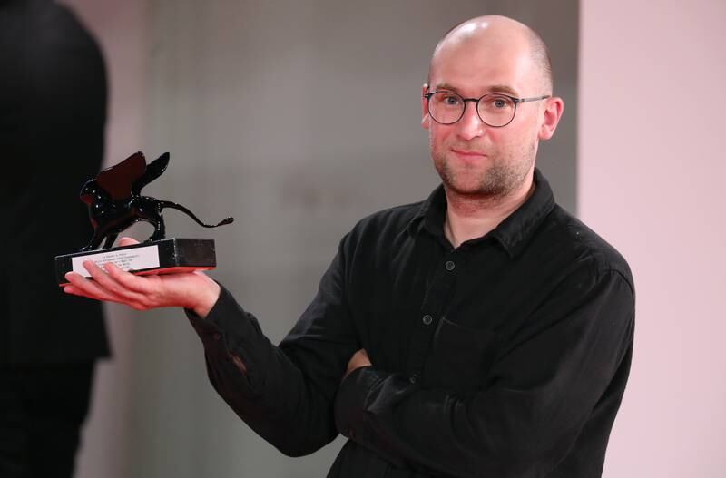 Director Laurynas Bareisa poses with the Orizzonti Award for Best Film for 'Piligrimai' (Pilgrims). Getty Images