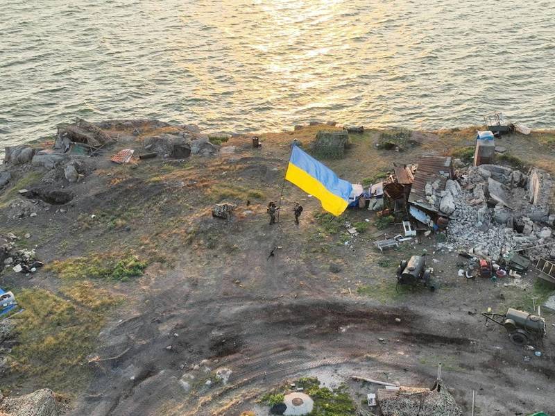 Ukrainian service members raise the national flag on Zmiinyi, or Snake Island, in the Odesa region as Russia's attack on Ukraine continues. Reuters