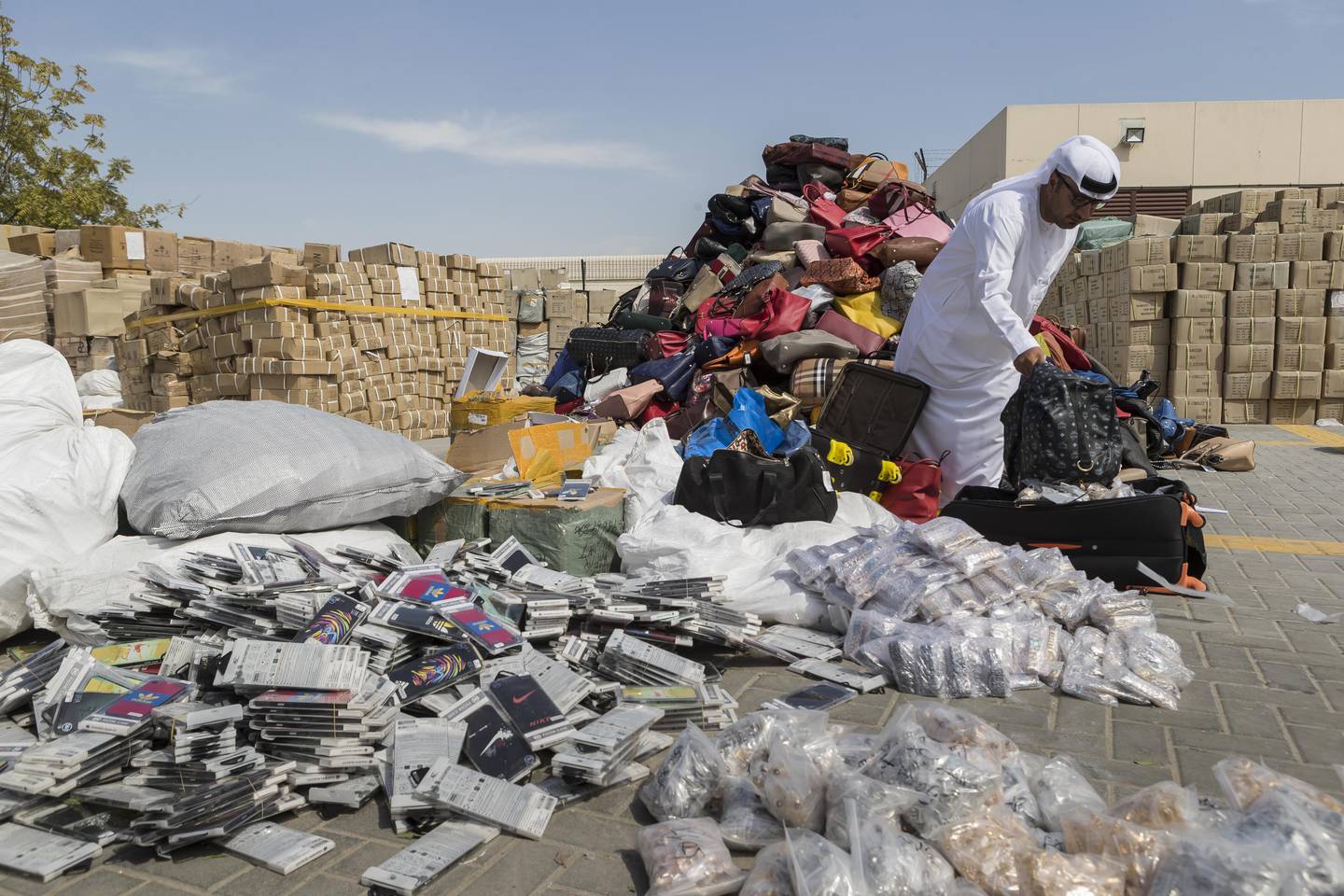 DUBAI, UNITED ARAB EMIRATES, 08 FEBRUARY 2017. Ibrahim Behzad, Director of Intellectual Property Rights Management at DED looks through a pile of counterfeit products at the DED in Al Garhoud. The products are scheduled to be distroyed and recycled. (Photo: Antonie Robertson/The National) ID: 75938. Journalist: Nick. Section: National. *** Local Caption ***  AR_0802_Fake_Goods-07.JPG