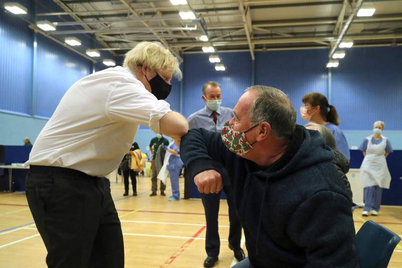 Boris Johnson speaks to members of the public as they wait to receive an Oxford-Astrazeneca vaccine. AFP