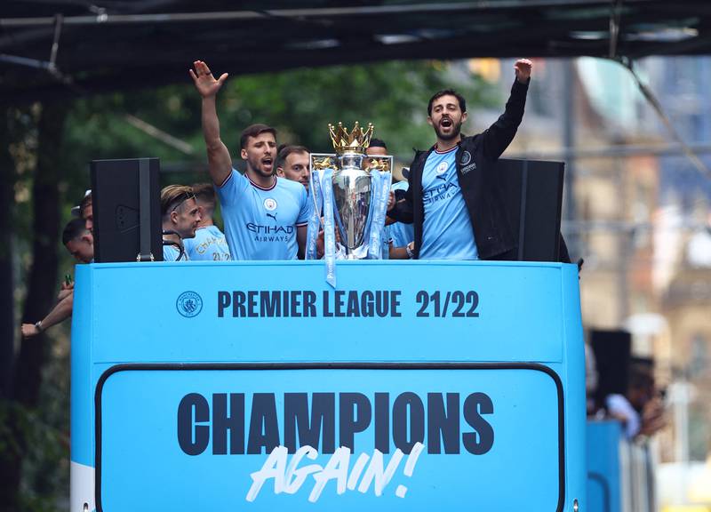 Manchester City's Ruben Dias and Bernardo Silva celebrate with the Premier League trophy during the victory parade. Reuters