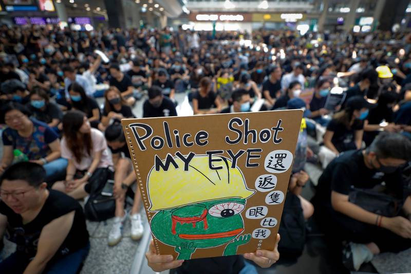 A protester displays a placard during a sit-in protest at the arrival hall of the Hong Kong International Airport in Hong Kong.  AP
