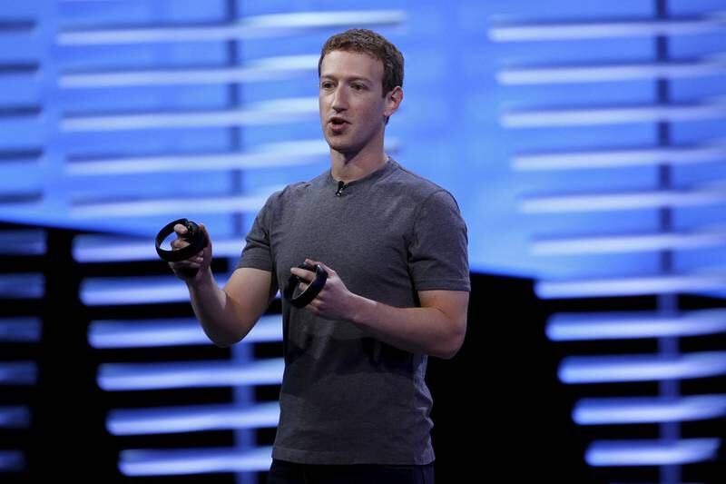 Meta chief executive Mark Zuckerberg holds a pair of touch controllers for the Oculus Rift virtual reality headsets. Reuters
