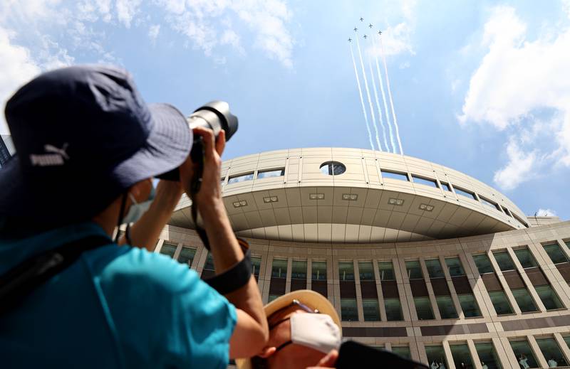People take photos of the Japan air force aerobatic squadron Blue Impulse.