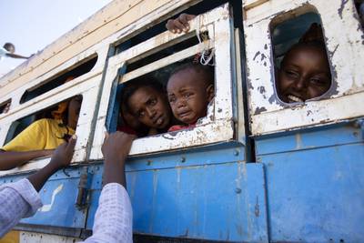 Refugees who fled the conflict in Ethiopia's Tigray region ride a bus going to the Village 8 temporary shelter, near the Sudan-Ethiopia border, in Hamdayet, eastern Sudan, on December 1, 2020