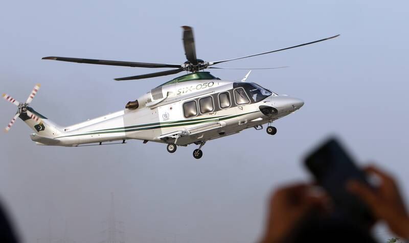 A helicopter carrying Mr Khan arrives at the rally. EPA
