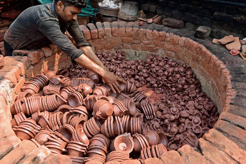 A potter arranges traditional earthen oil lamps in an oven at a workshop, ahead of Navratri on the outskirts of Ahmedabad. AFP