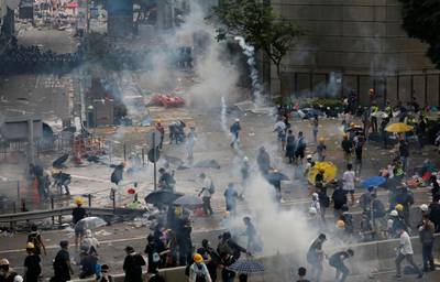Riot police fire tear gas toward protesters. AP