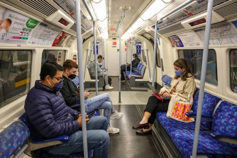 Commuters wear masks on a London Underground train.