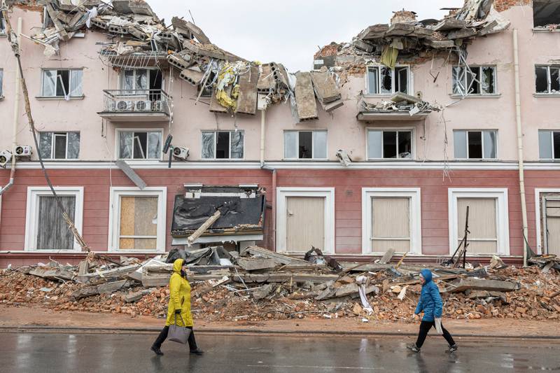 Women pass in front of the destroyed Hotel Ukraine in Chernihiv, as Russia's invasion of Ukraine continues. Reuters