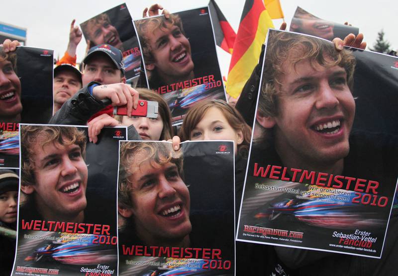 Fans of newly crowned Formula One world champion Sebastian Vettel hold up posters ahead of his arrival at his home town Heppenheim in 2010. AFP