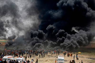Palestinians burn tires at the border fence with Israel, east of Jabalia in the central Gaza city, during a protest on April 13. Several thousand Gazans gathered for a third consecutive Friday of mass protests along the border with Israel after violence in which Israeli forces have killed 33 Palestinians and wounded hundreds of others. Mohammed Abed / AFP Photo