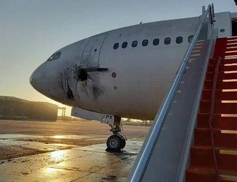 A handout picture released by the Facebook page of the Iraqi ministry of transportation, shows a damaged stationary aircraft on the tarmac of Baghdad airport, after rockets reportedly targeted the runway, on January 28, 2022.