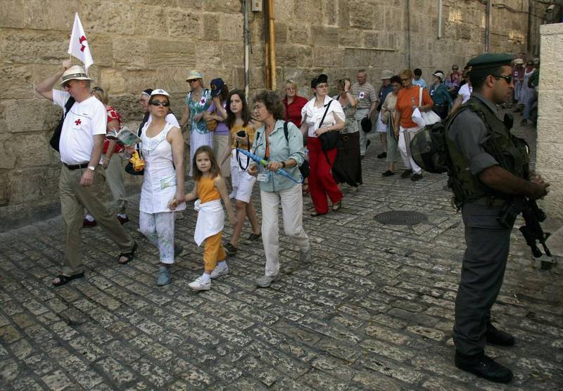 Tourists walk past an Israeli border police officer in Jerusalem's Old City. Ronen Zvulun / Reuters 