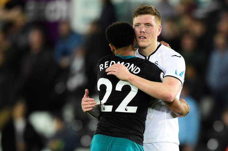 Soccer Football - Premier League - Swansea City v Southampton - Liberty Stadium, Swansea, Britain - May 8, 2018   Swansea City's Alfie Mawson hugs Southampton's Nathan Redmond after the match   REUTERS/Rebecca Naden    EDITORIAL USE ONLY. No use with unauthorized audio, video, data, fixture lists, club/league logos or "live" services. Online in-match use limited to 75 images, no video emulation. No use in betting, games or single club/league/player publications.  Please contact your account representative for further details.