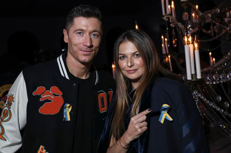 Robert Lewandowski and wife Anna Lewandowska wear ribbons in support of Ukraine at Paris Fashion Week. AP