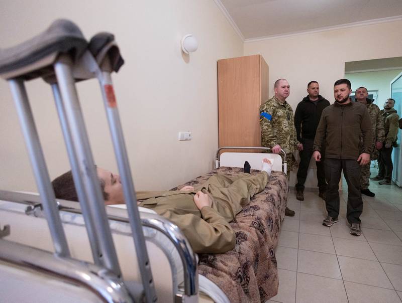 Ukraine's President Volodymyr Zelenskiy speaks to an injured Ukrainian service member, as Russia's attack on Ukraine continues, during a visit to a military hospital in Kyiv, Ukraine April 3, 2022.  Reuters